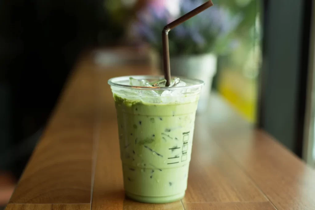 Green Smoothie in a disposable cup with a straw.