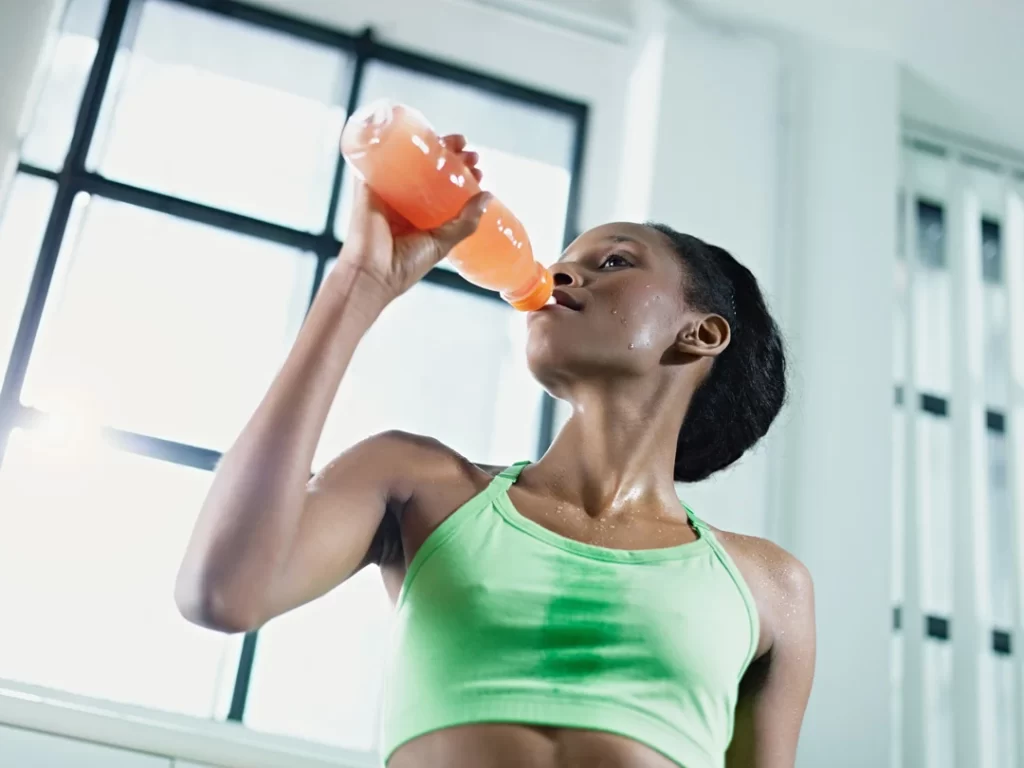 African-woman-in-gym-drinking-energy-drinkafrican.