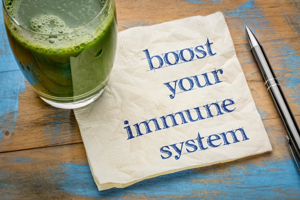 Boost your immune system written on paper with a pen with a drink on the side.