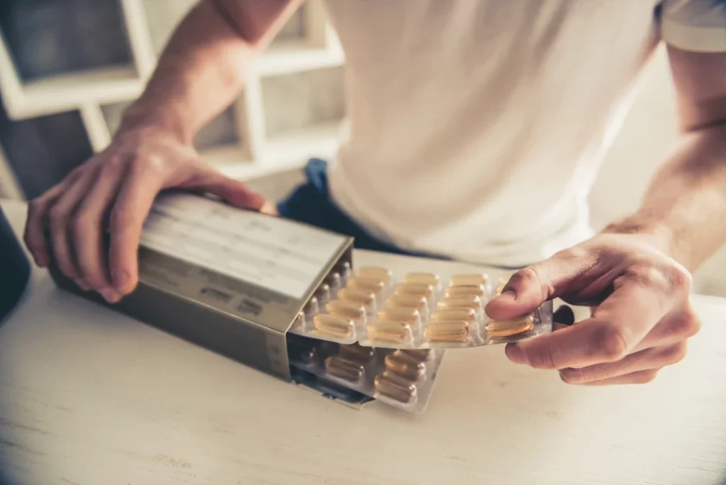 Man with sport nutrition tablets.