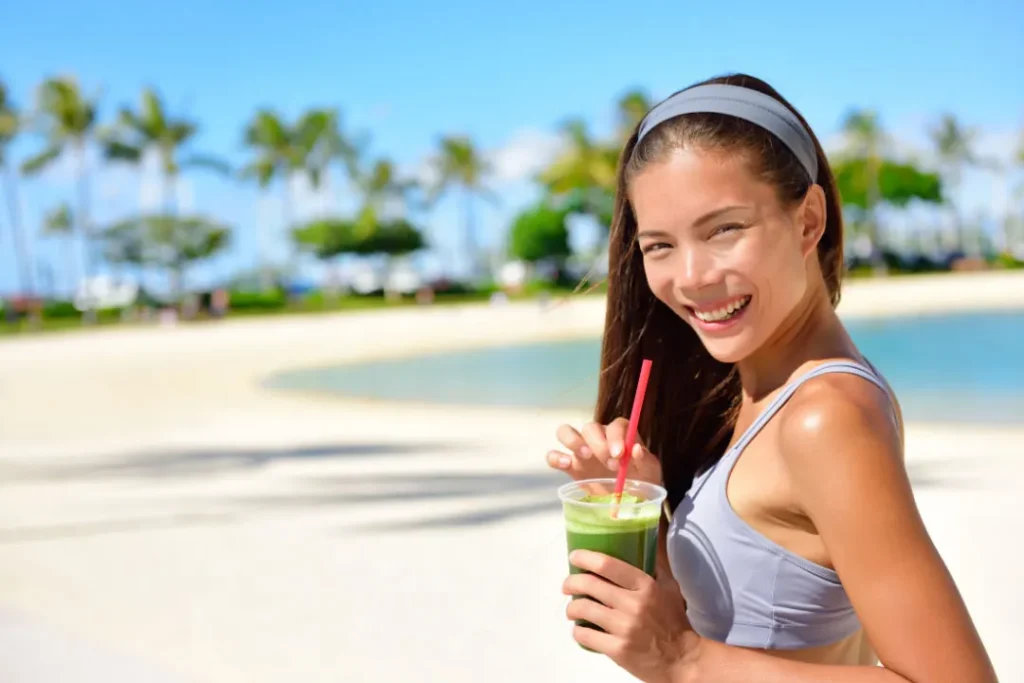 A lady having green juice. 