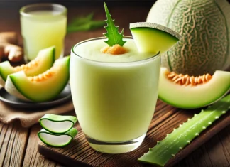 A refreshing pale green melon aloe vera smoothie in a clear glass, garnished with a small aloe vera leaf and a slice of honeydew melon. The setting includes a wooden table with fresh honeydew melon slices, a small glass of aloe vera juice, and a piece of fresh ginger, emphasizing the smoothie’s hydrating and stomach-soothing benefits.