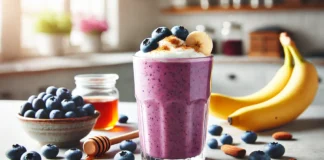 A creamy blueberry-banana smoothie in a tall glass, topped with fresh blueberries and a sprinkle of cinnamon, set in a bright kitchen with natural lighting.